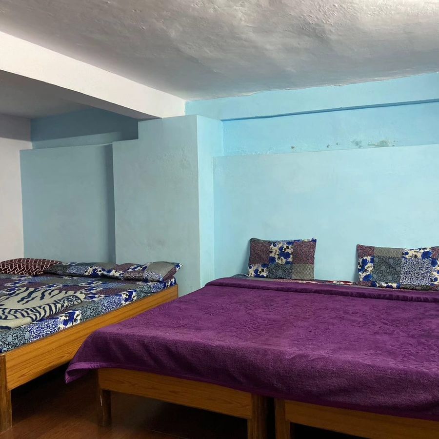 Spacious blue bedroom with beds at sunny home stay