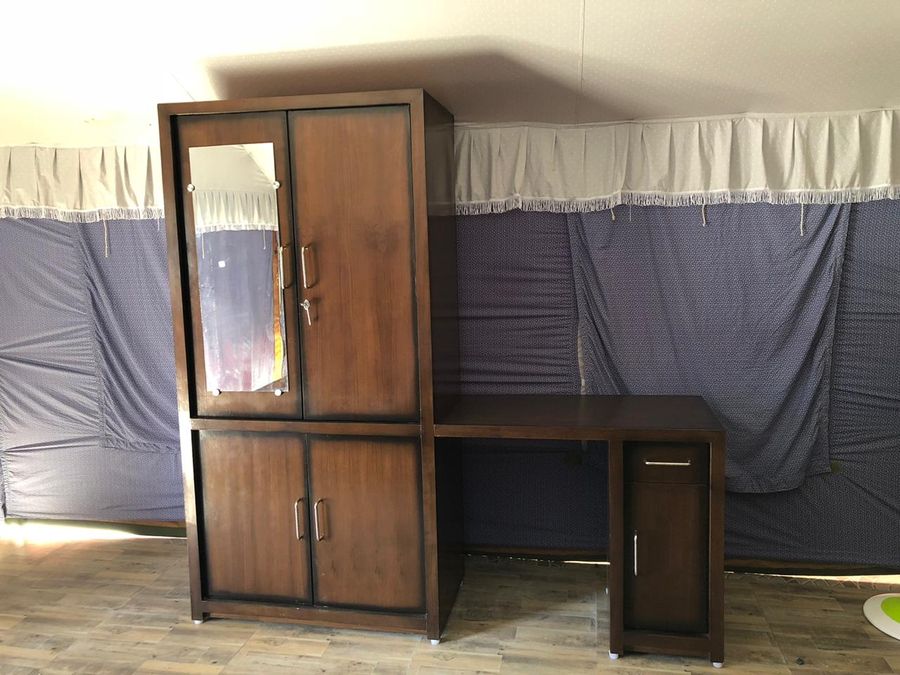 Wooden wardrobe and dressing desk unit inside the tent accommodation in Rishikesh