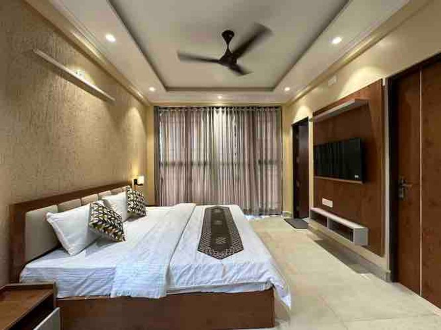 Modern master bedroom with cove ceiling lighting and double bed in Bhimtal