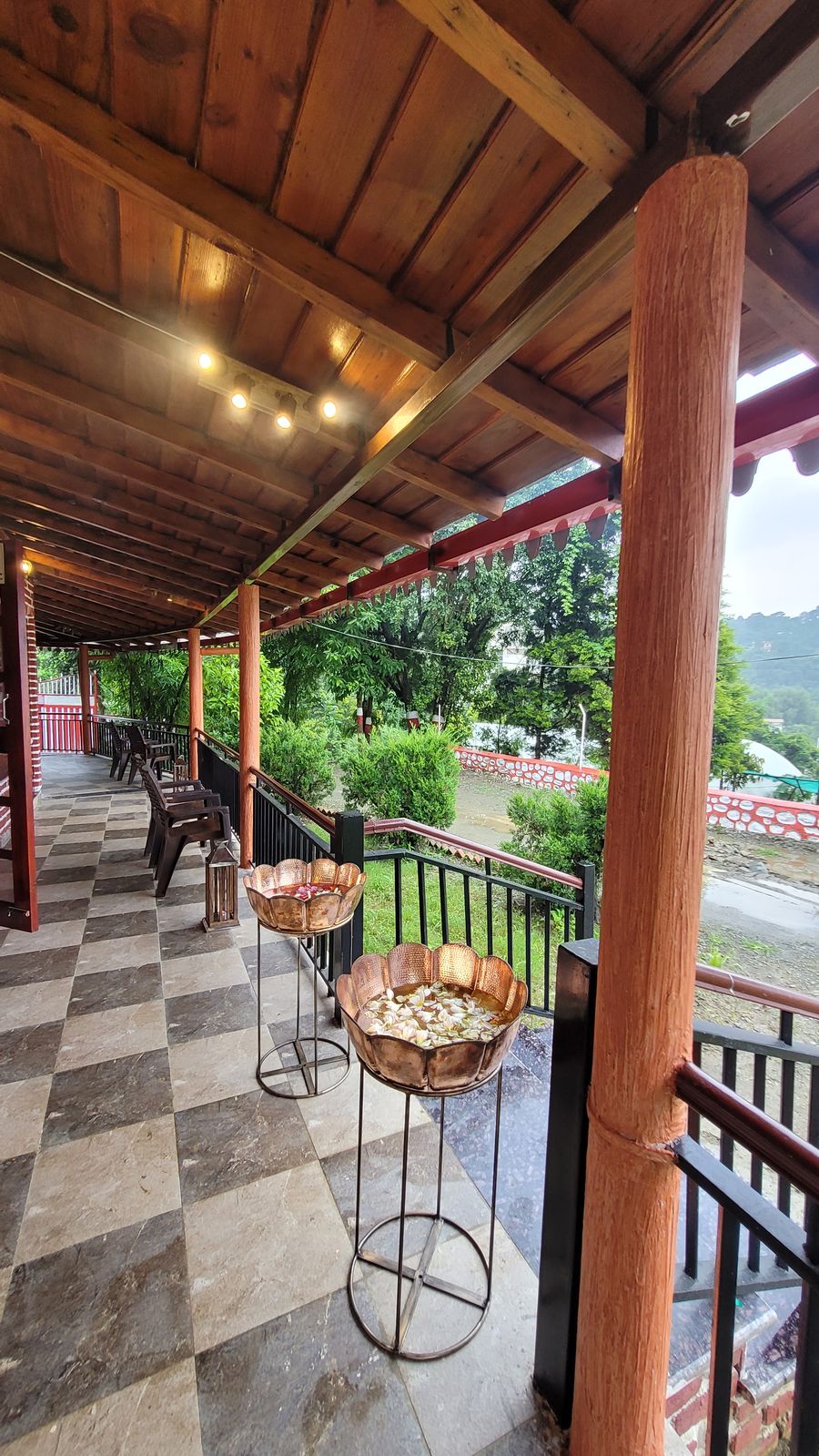 Covered outdoor veranda corridor overlooking scenic forest views in Bhimtal
