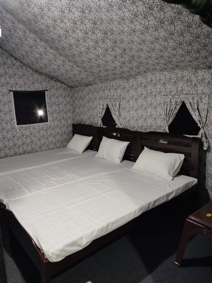 Spacious luxury tent setup with triple bedding in Bhimtal