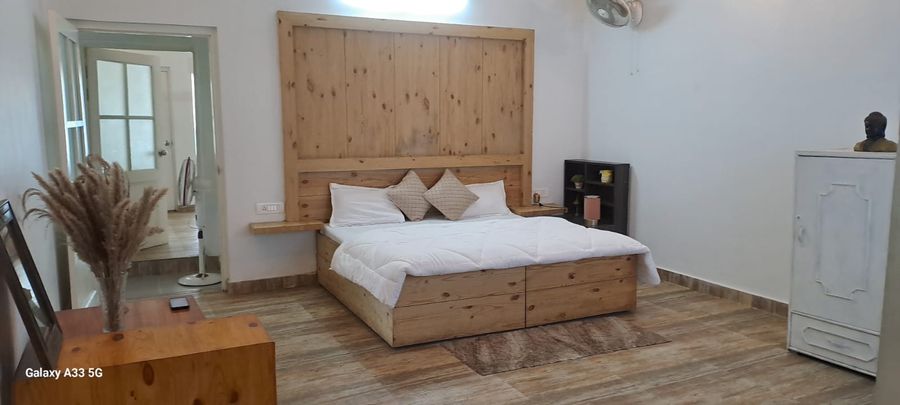 Comfortable double bed with custom wooden headboard in Bhimtal