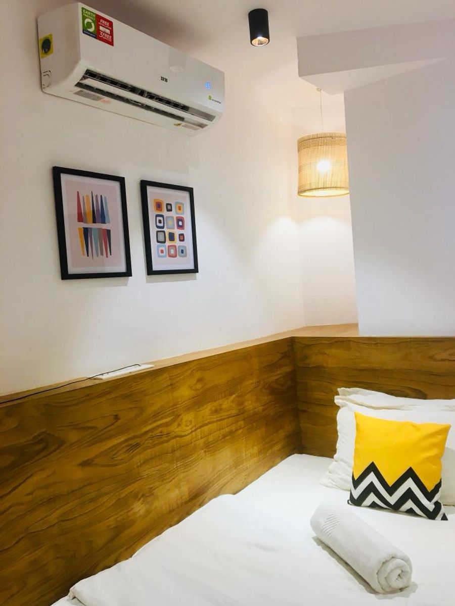Cozy wooden headboard bed corner view in pod room 303 goa