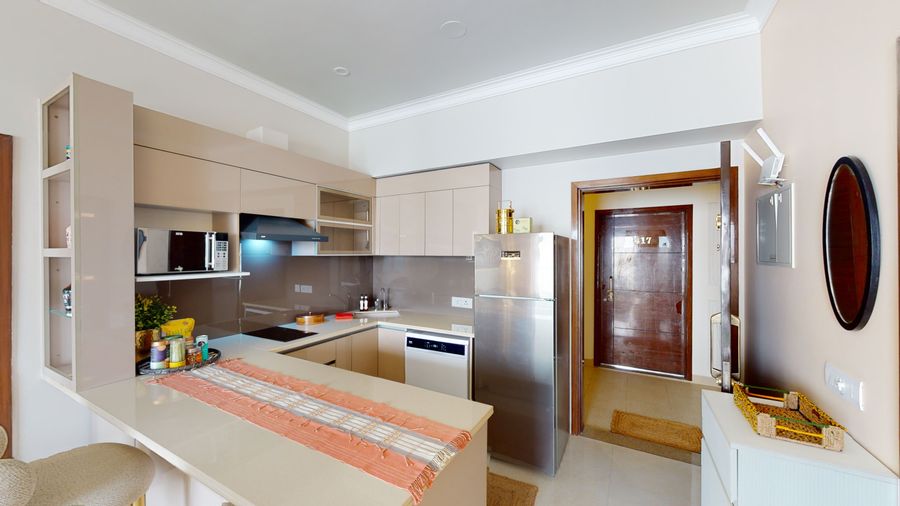 Modern open kitchen with dining at priya living flower valley