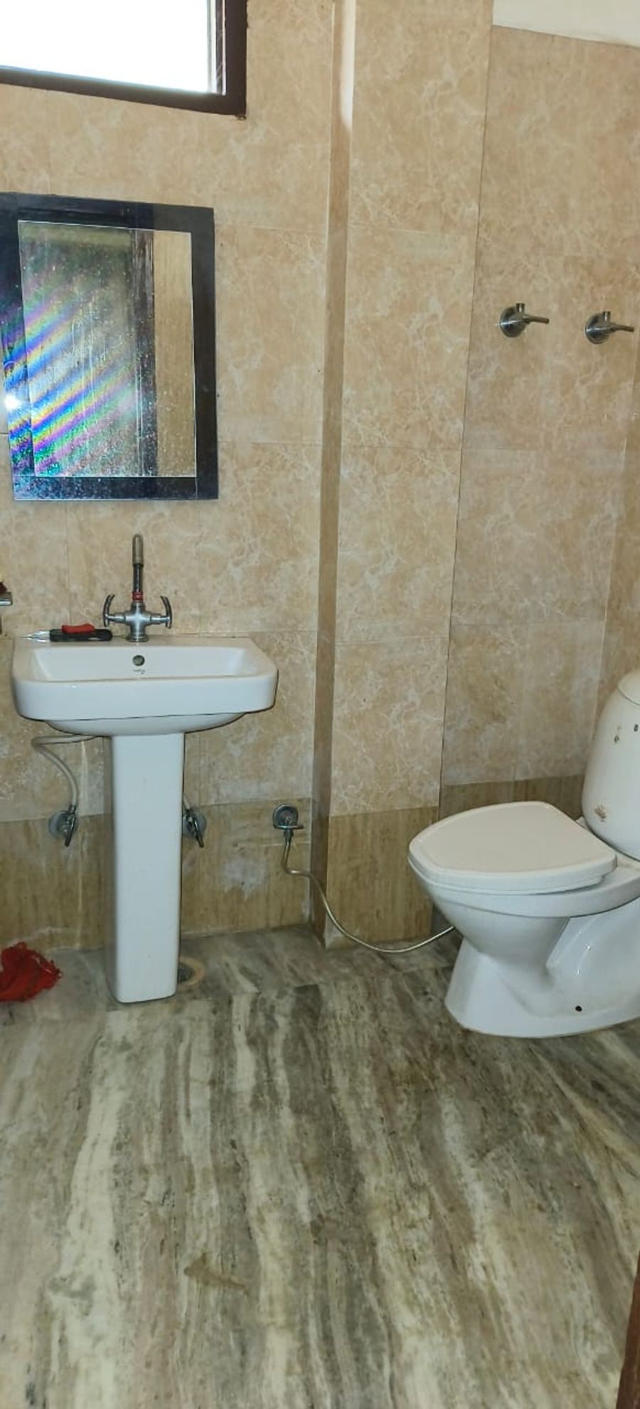 Clean bathroom washbasin and western toilet setup in Bhimtal