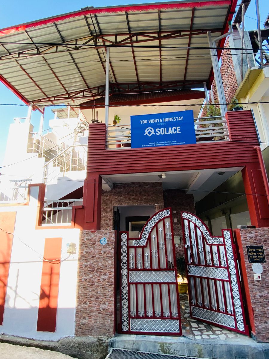 Residential homestay exterior with gated entrance and terrace signboard in Rishikesh
