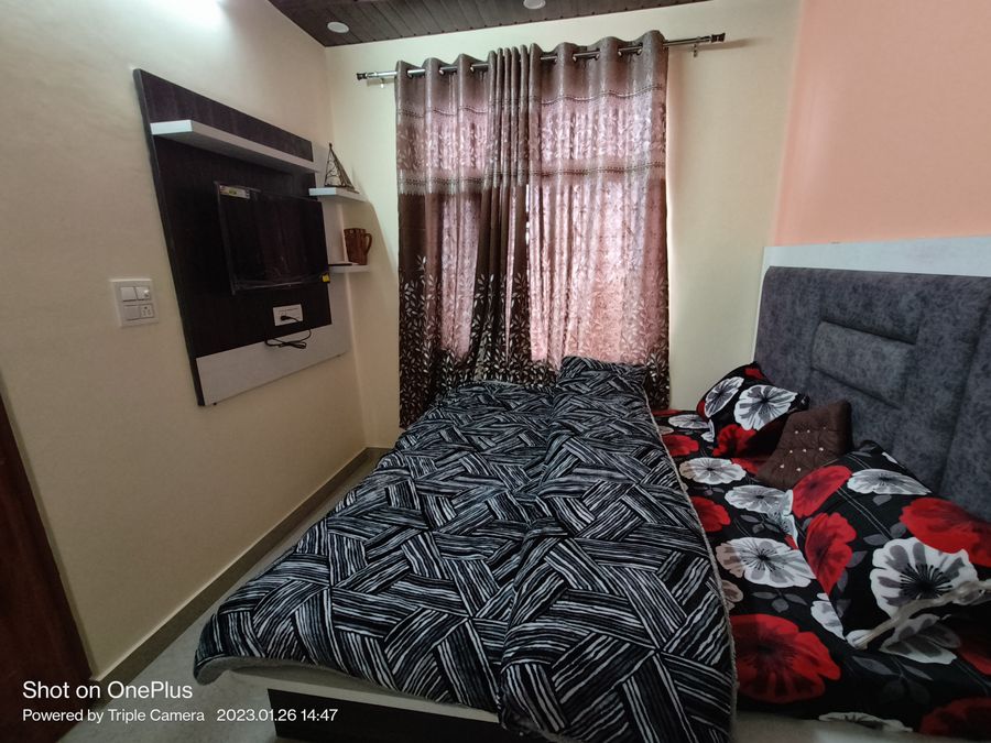 Cozy bedroom setup with patterned bedding in Kasauli homestay
