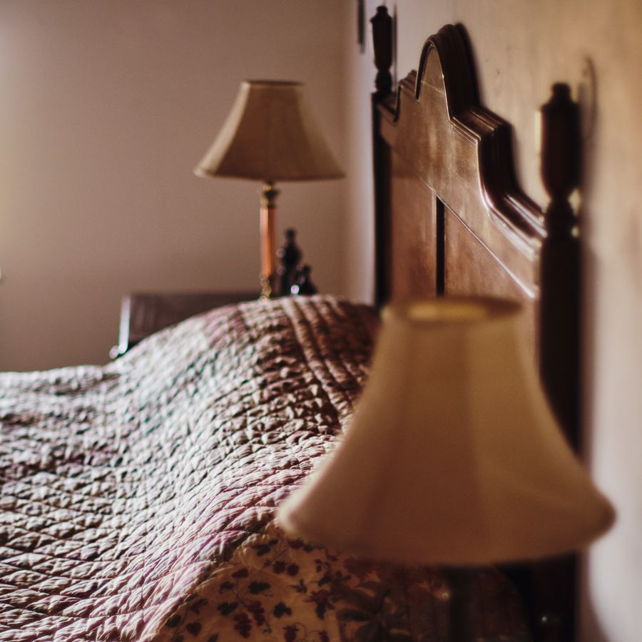 Vintage bedside lamp and textured bedding in Kasauli room