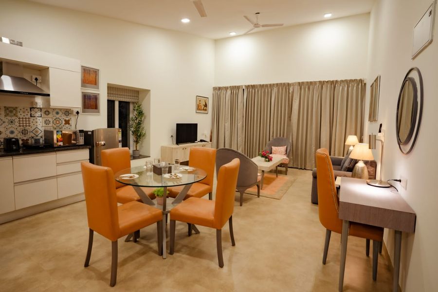 Indoor dining area with orange chairs luxury apartment goa