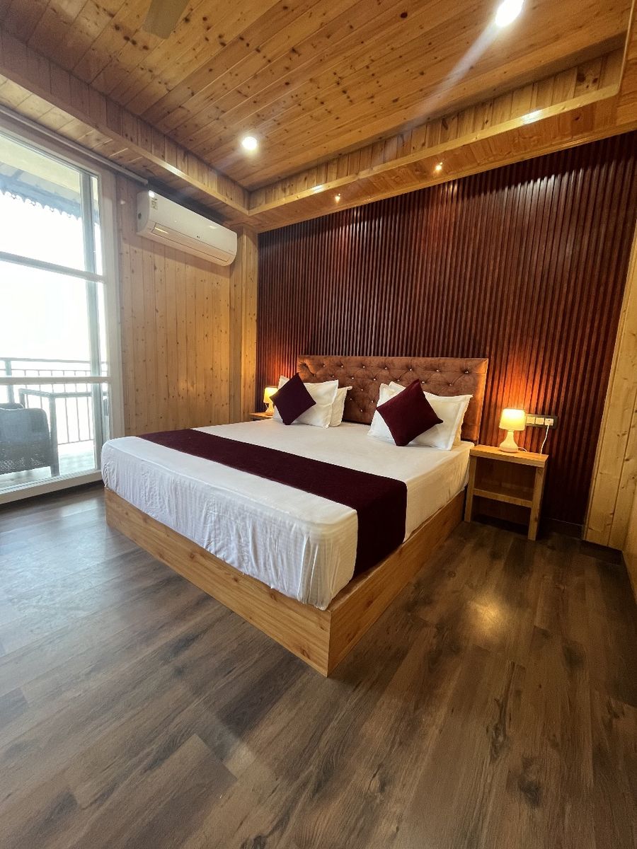 Master bedroom with wooden floor and double bed in Kasauli