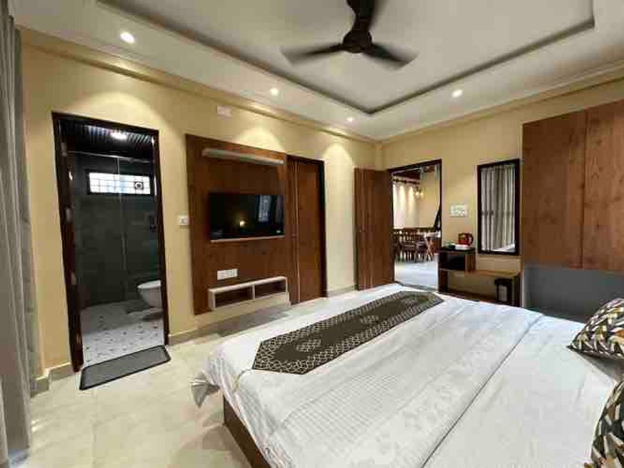 Bright bedroom with stylish dressing mirror and wooden accents in Bhimtal