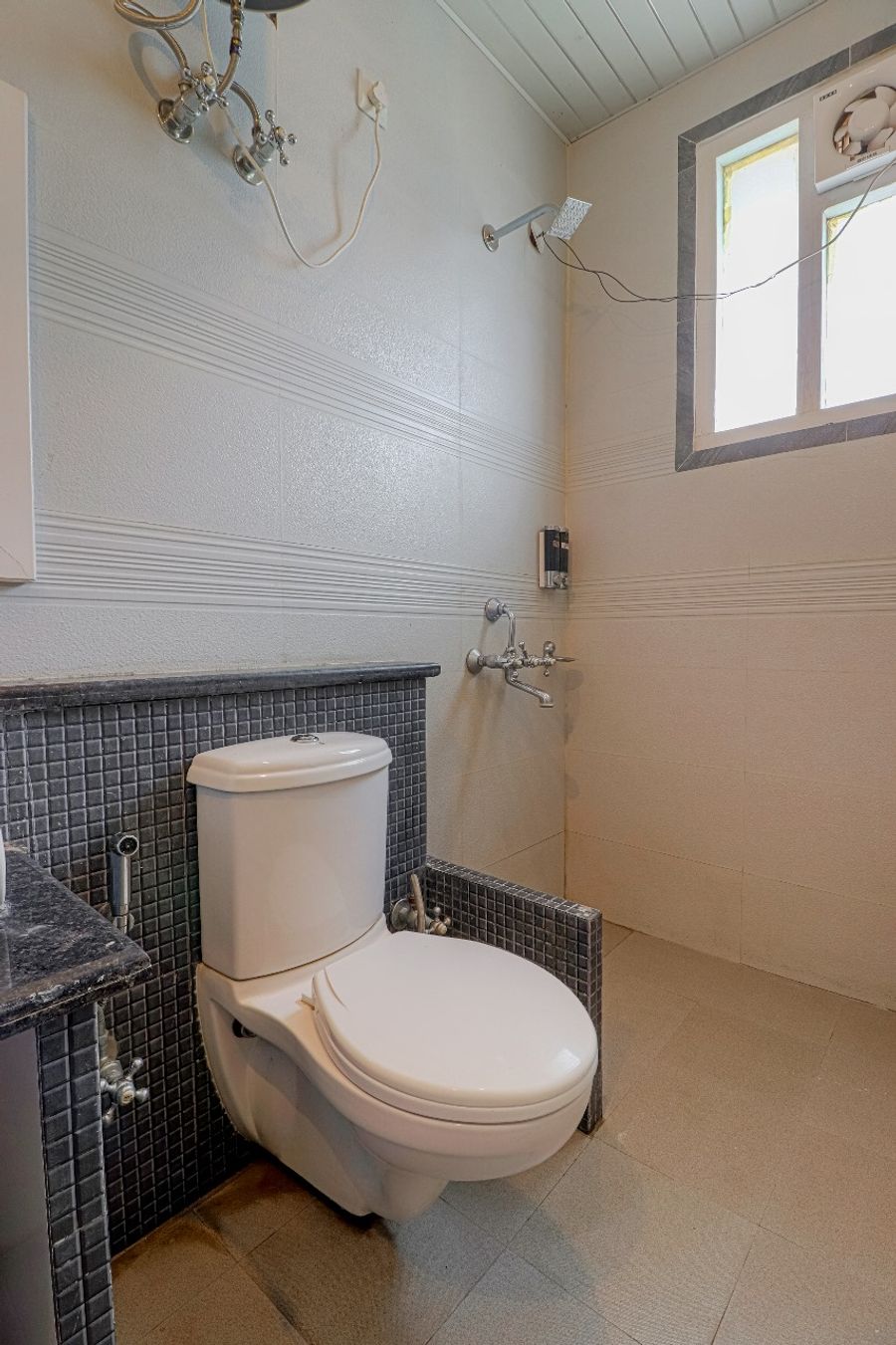 Clean tiled washroom with toilet hotel in dehradun