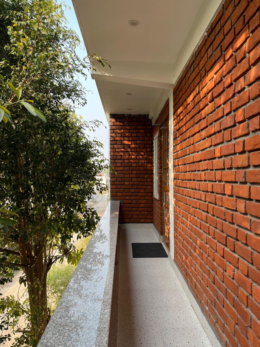 Exposed brick exterior wall with balcony in Rishikesh