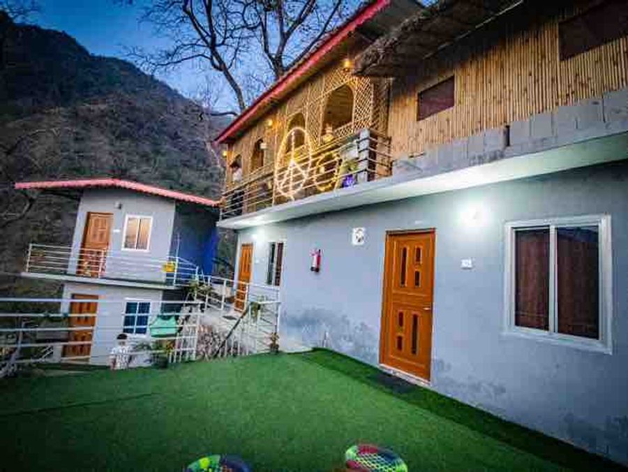 Two-story stone homestay exterior with open mountain-facing courtyard in Rishikesh.