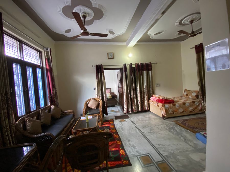 Bright common hall area with sofa seating and open bedroom partition in Rishikesh