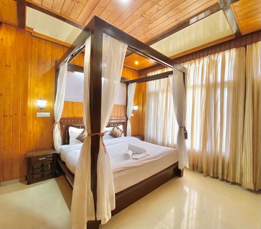 Romantic four-poster canopy bed in wooden room Kasauli
