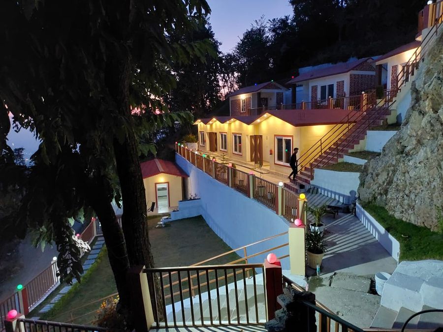Twilight view of illuminated standard cottage row and stepped stone pathway in Rishikesh