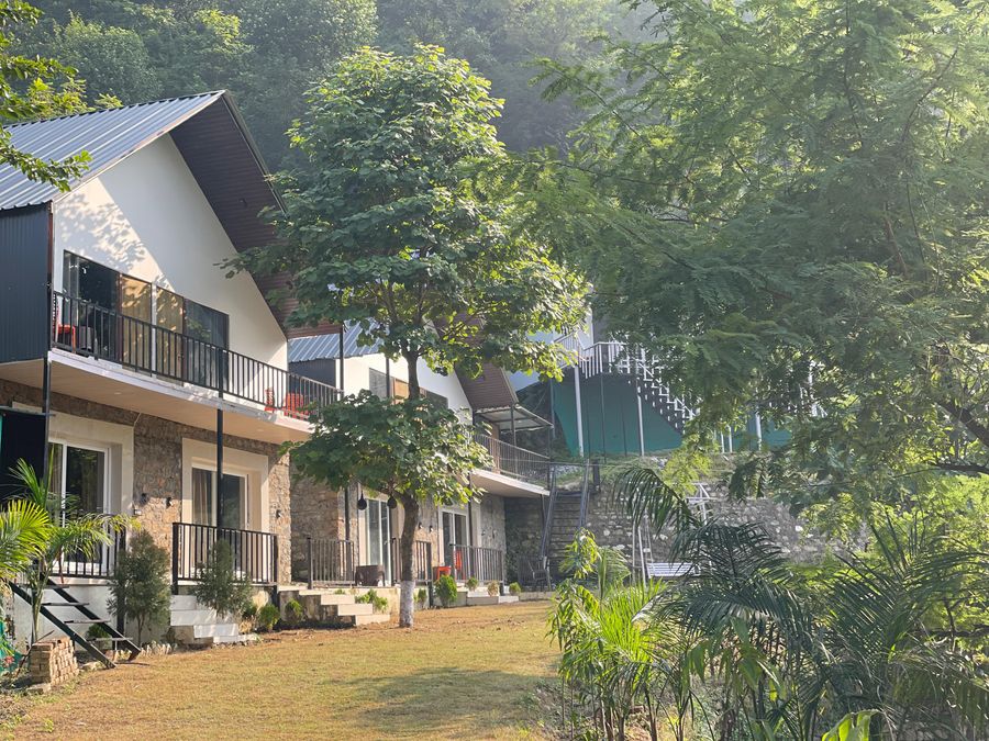 Charming row of modern villa cottages surrounded by wooded hillside slopes in Rishikesh