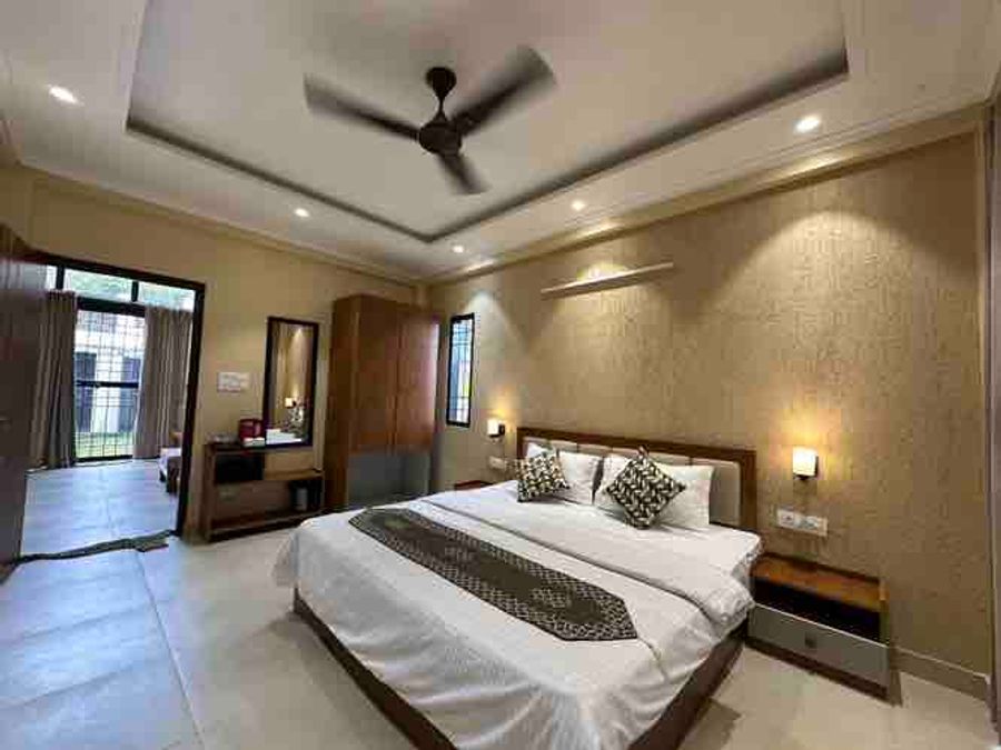 Spacious bedroom interior featuring wooden wardrobes and double bed in Bhimtal