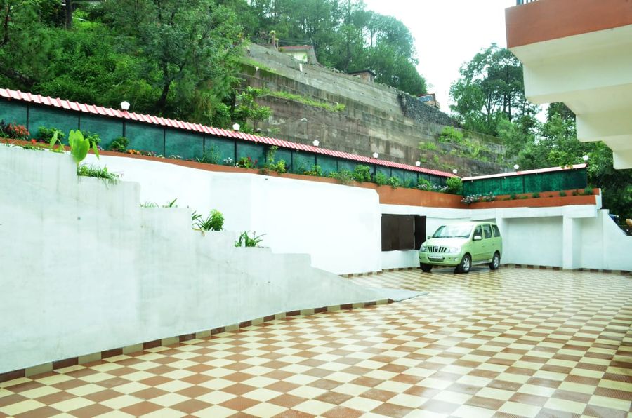 Spacious outdoor tiled courtyard and parking area in Kasauli