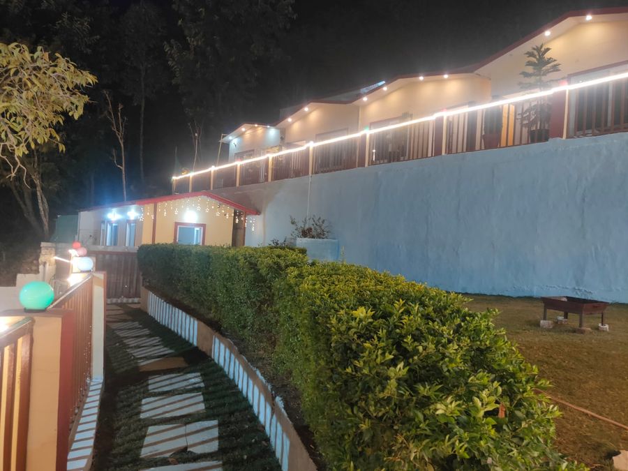 Evening view of the garden path and terrace steps illuminated by warm lights in Rishikesh