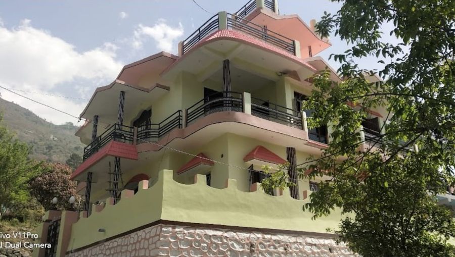 Exterior view of multi-story hillside homestay in Bhimtal