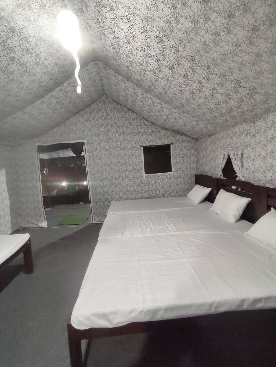 Clean glamping tent bedroom with pristine white linens in Bhimtal