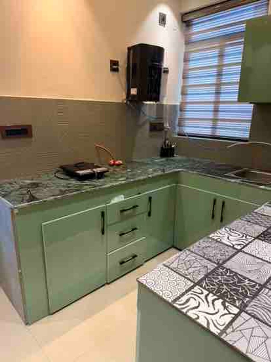 Modular kitchen green cabinets counter at luxury loft karnal