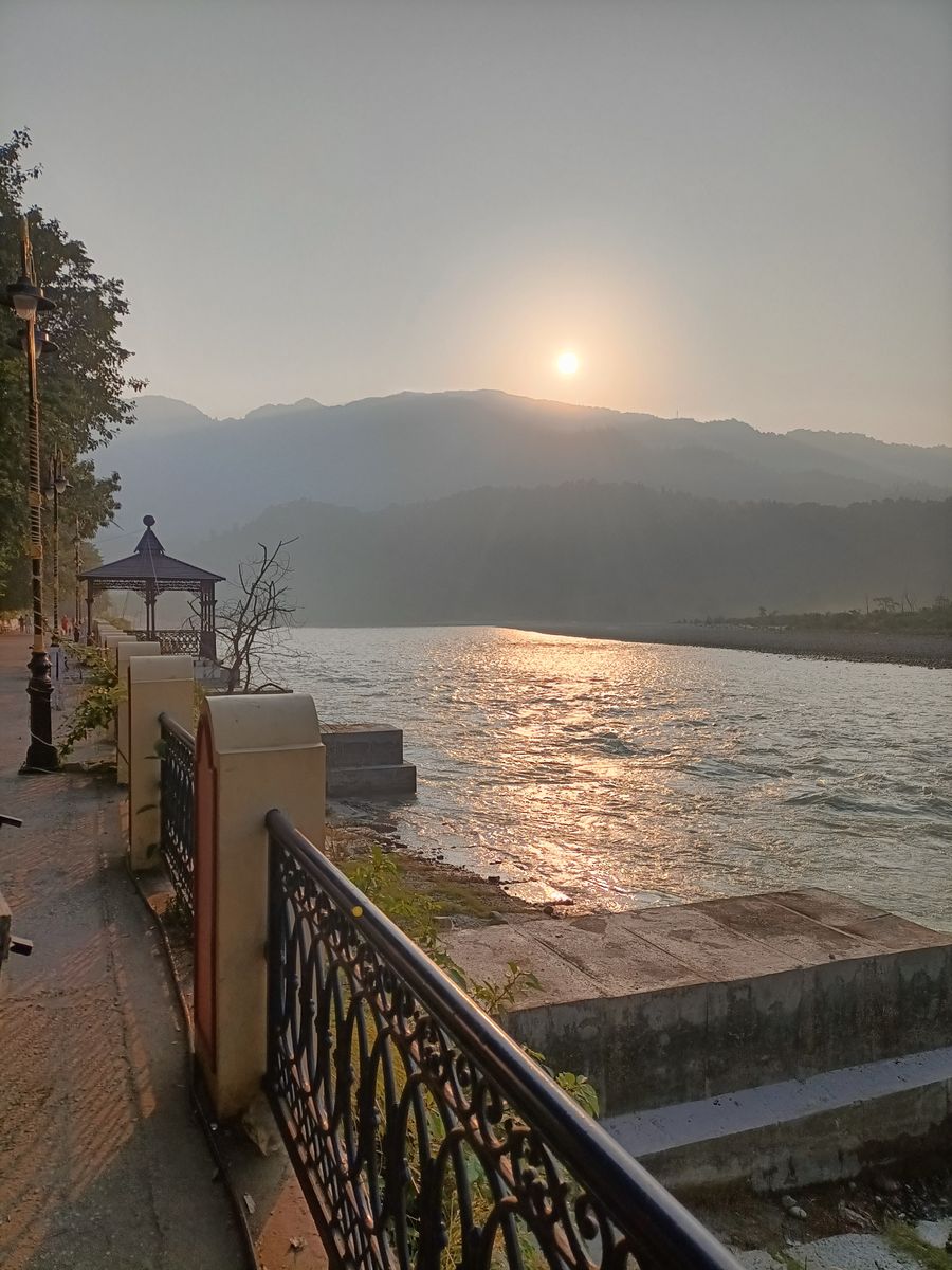 Sunset view over the tranquil Ganges riverbank and mountain horizon in Rishikesh