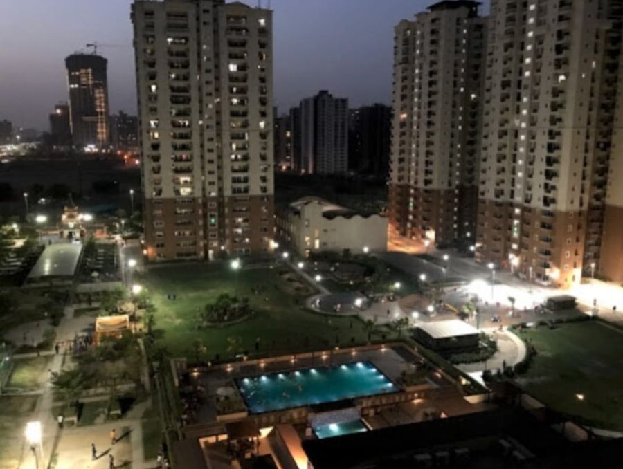 Illuminated night pool and high rise view three knots noida