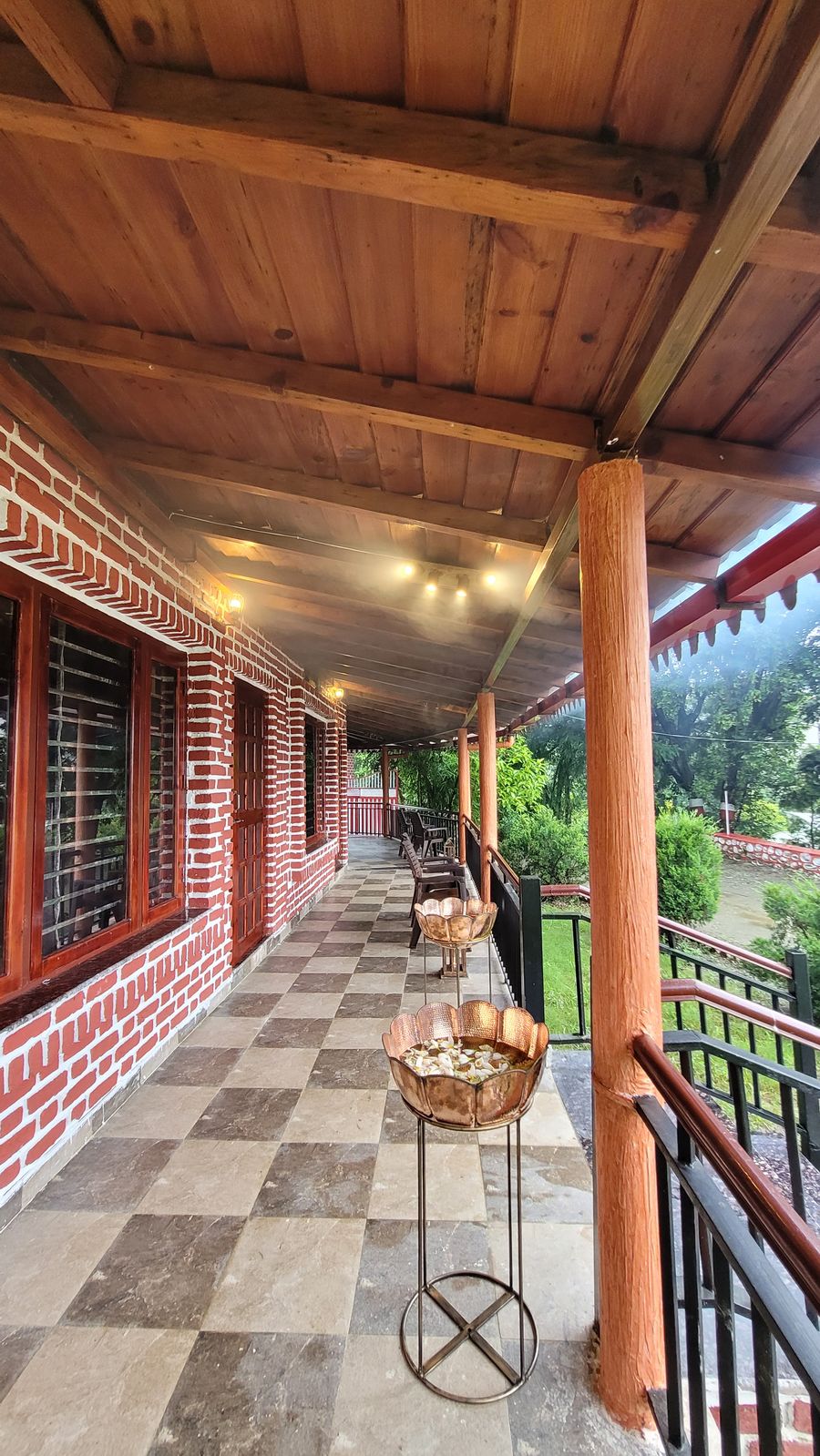 Brick-pillar veranda corridor with cozy outdoor seating in Bhimtal