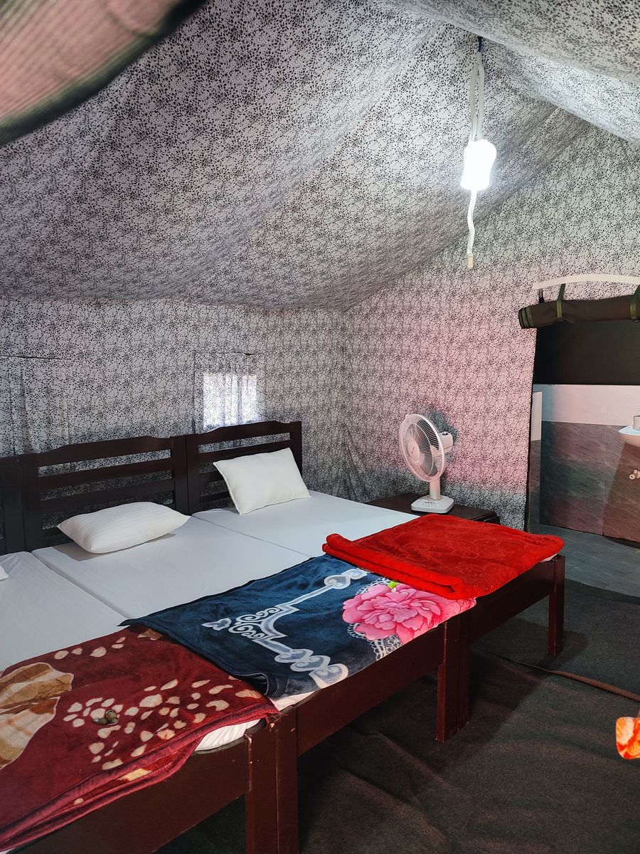 Cozy glamping tent interior with comfortable double bed in Bhimtal