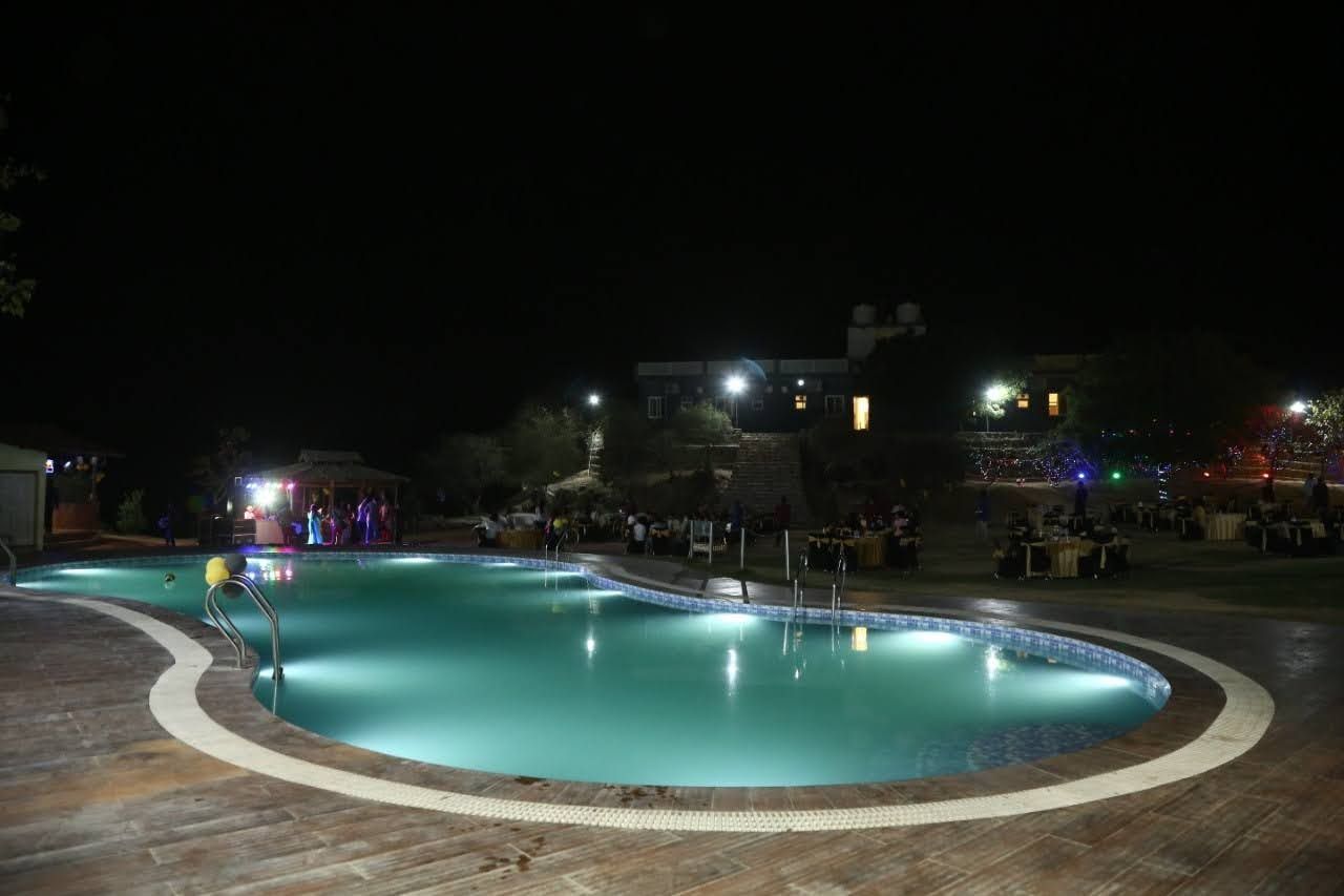 Night outdoor swimming pool lights near by farmhouse stay