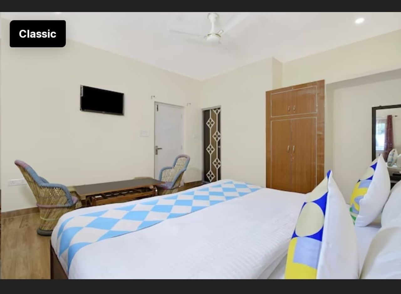 Bright bedroom with cane seating chairs and wardrobe in Bhimtal