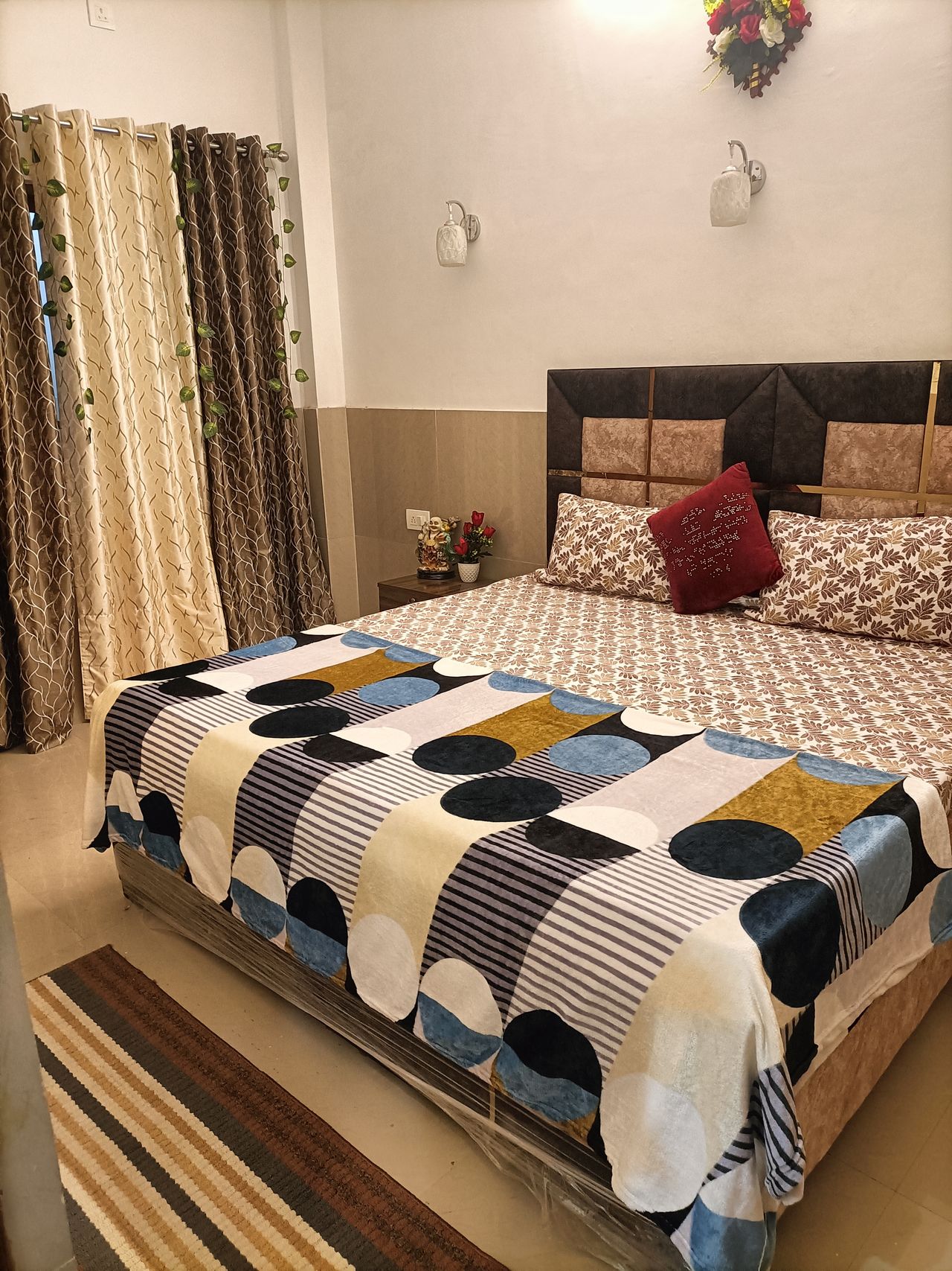 Bright bedroom with geometric printed bedding and curtained window in Rishikesh