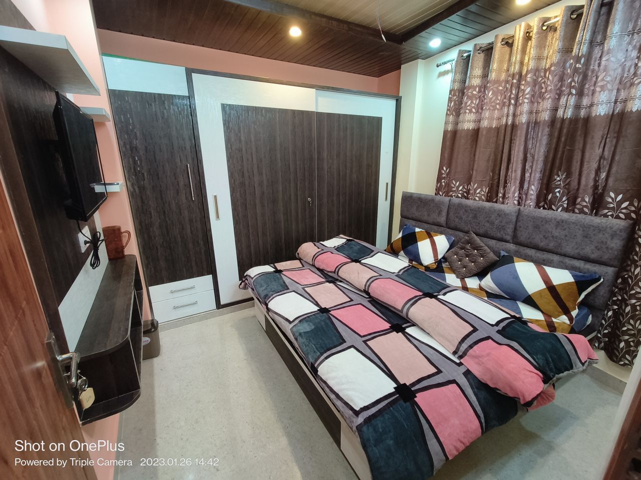 Comfortable double bed with wooden wardrobe storage in Kasauli